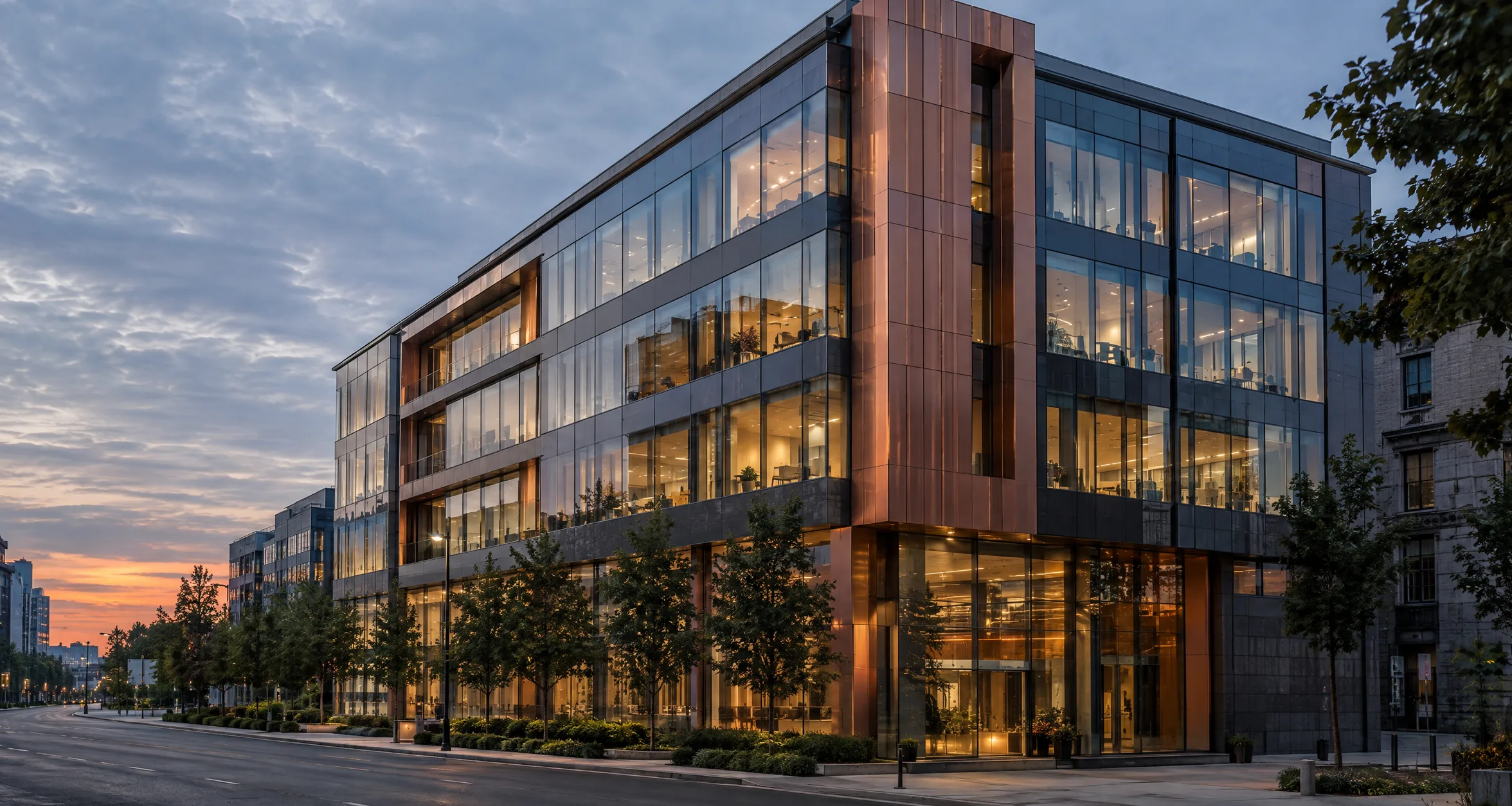 Exterior of a modern office building with glass and copper cladding at dusk